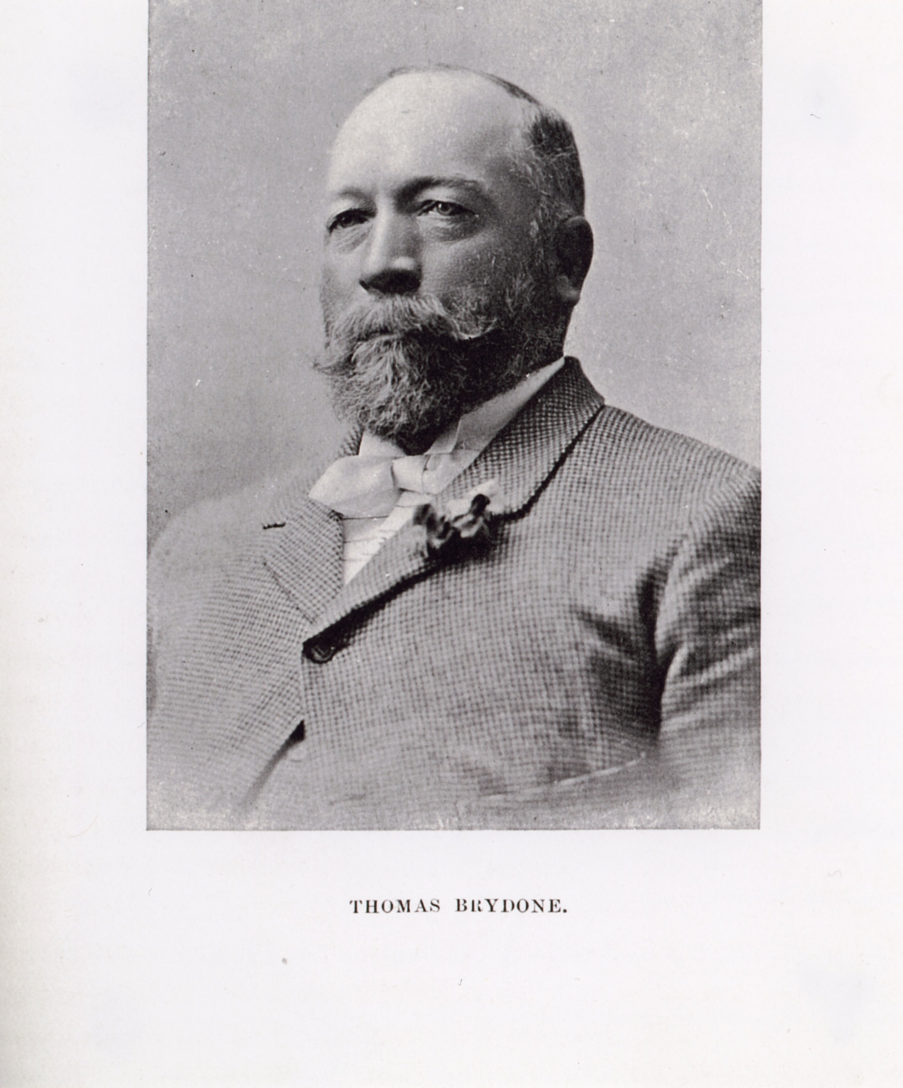 Black and white photo of man with beard and moustache wearing jacket and bowtie