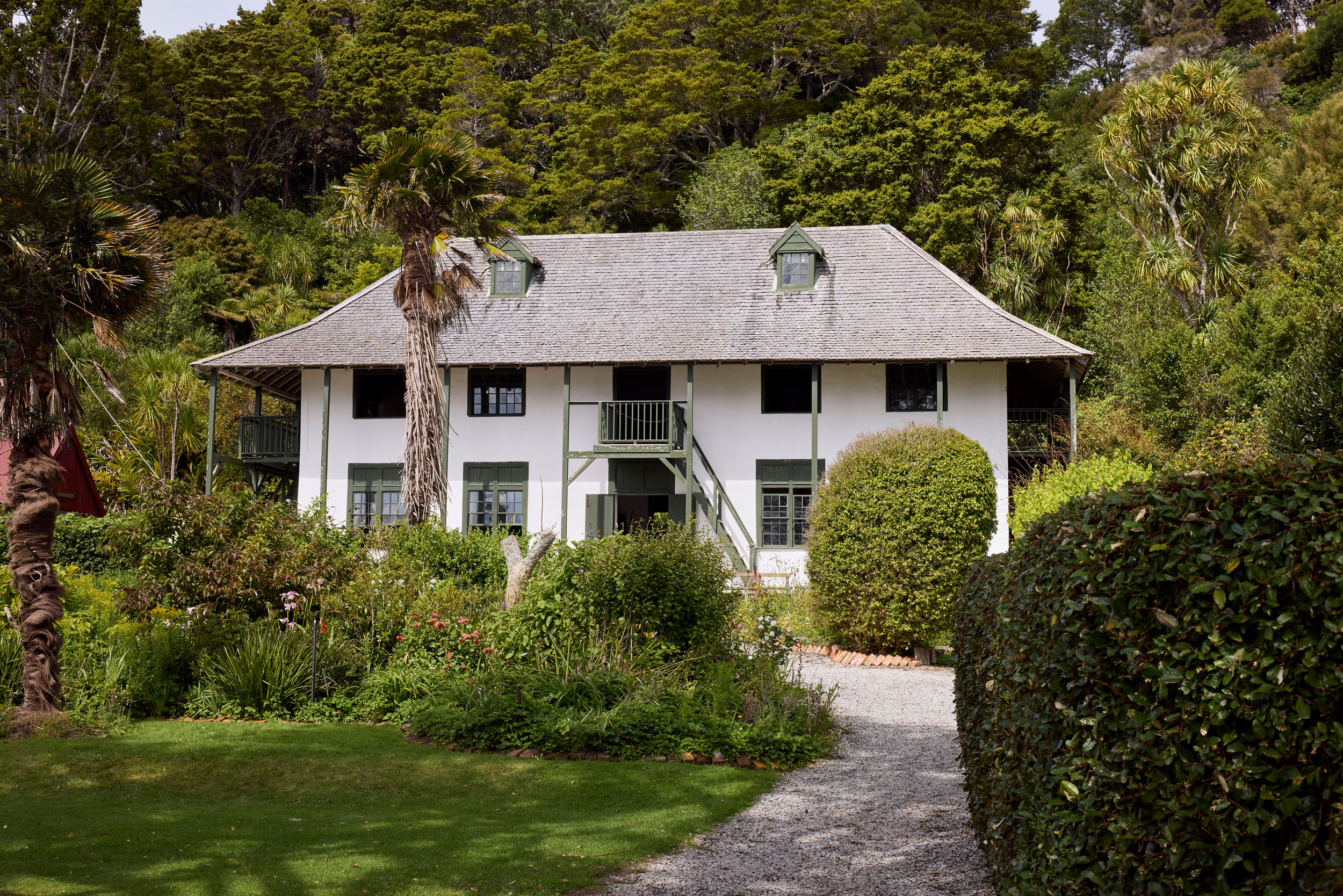 white plastered two storied building with hipped roof against native bush