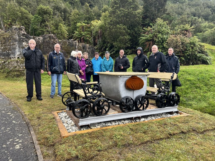 A group of people stand behind new picnic table