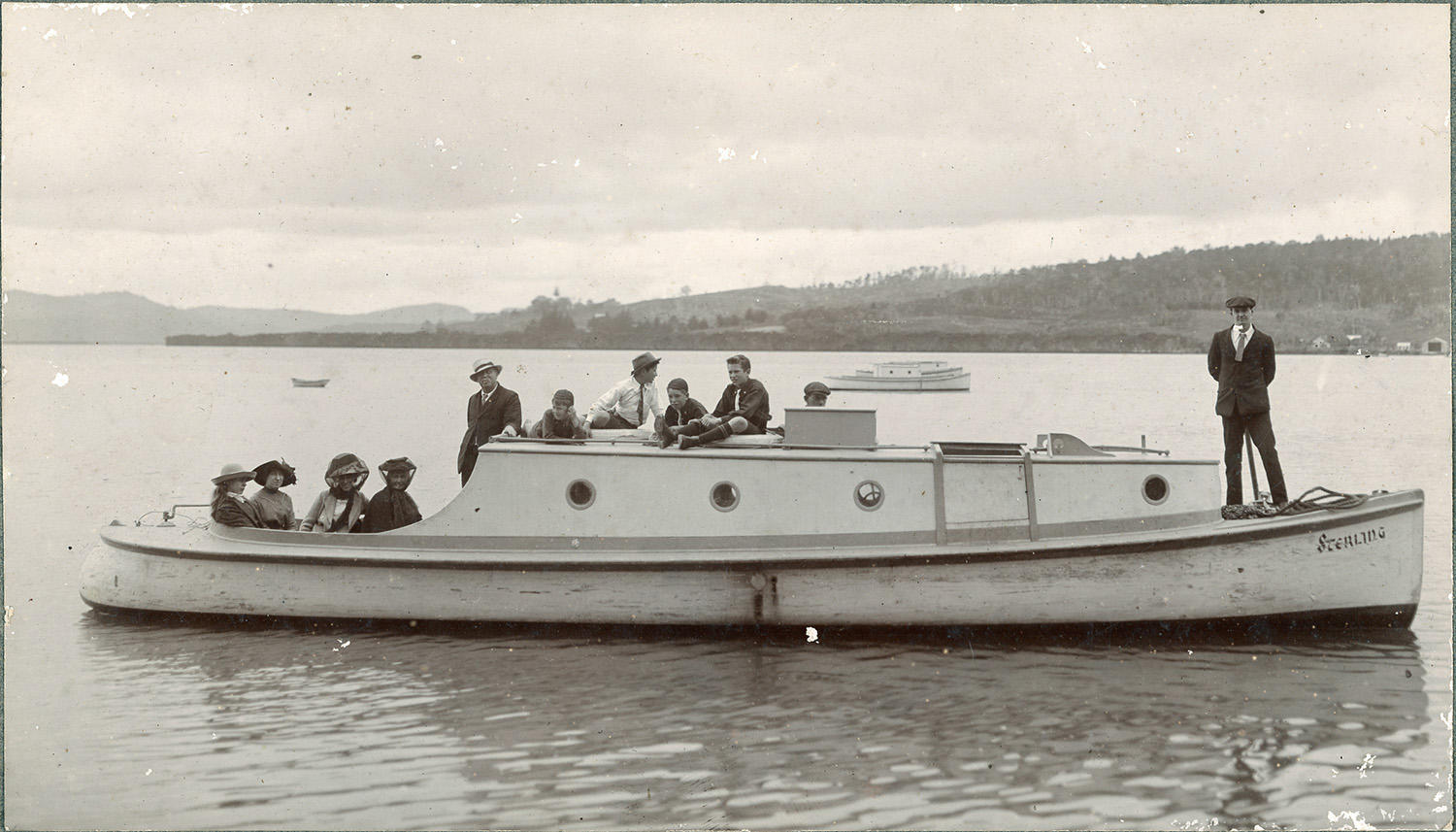 Black and white photo of family party on a boat, on the water