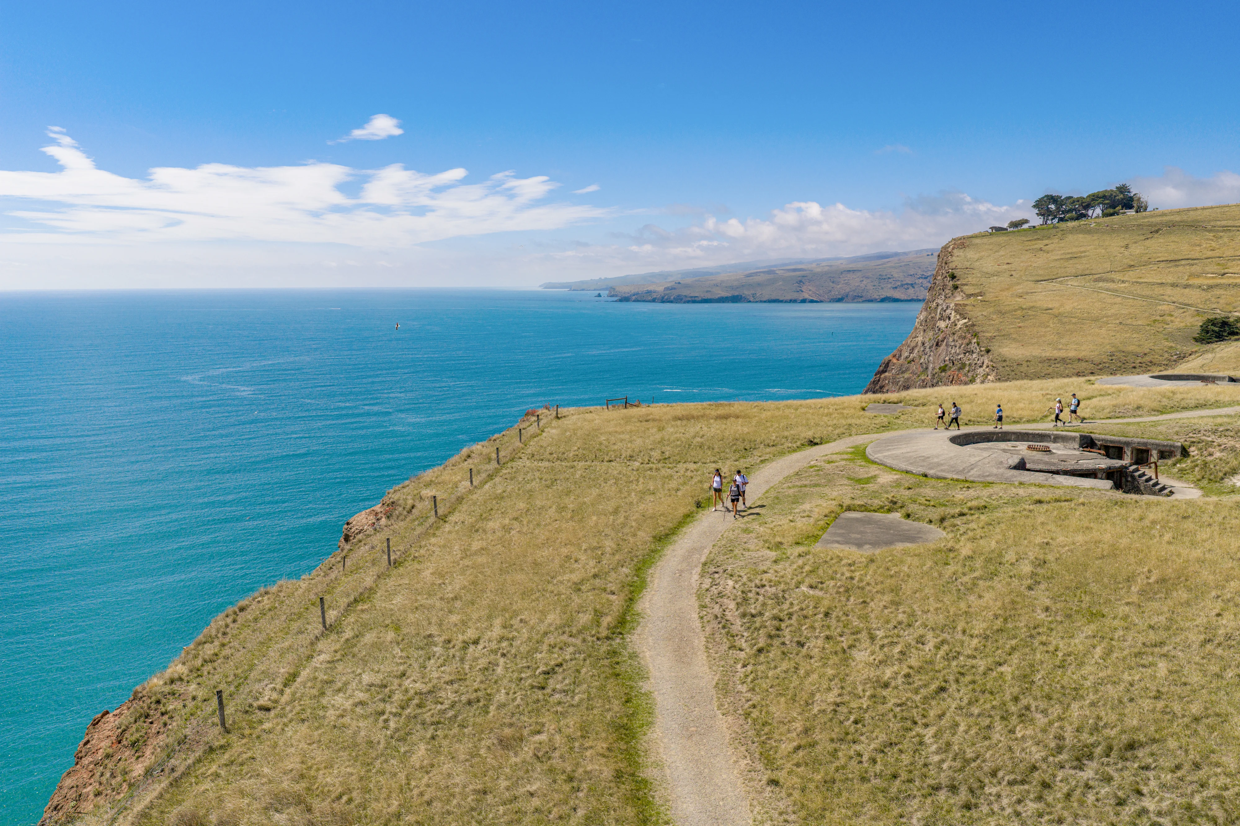Awaroa Godley Head drone photo with people walking along the edge and ocean behind