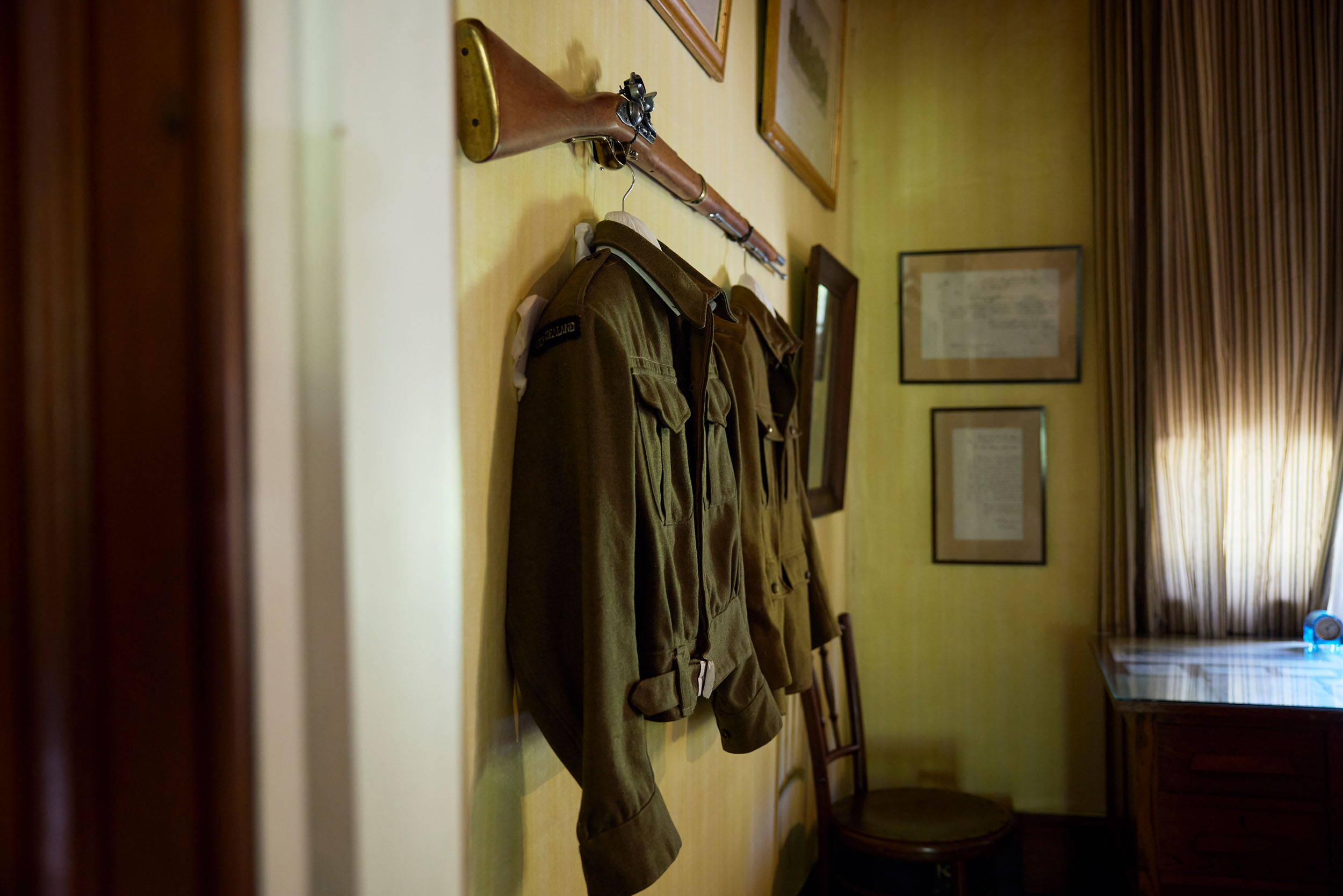 military jacket and gun displayed inside old cottage on the wall