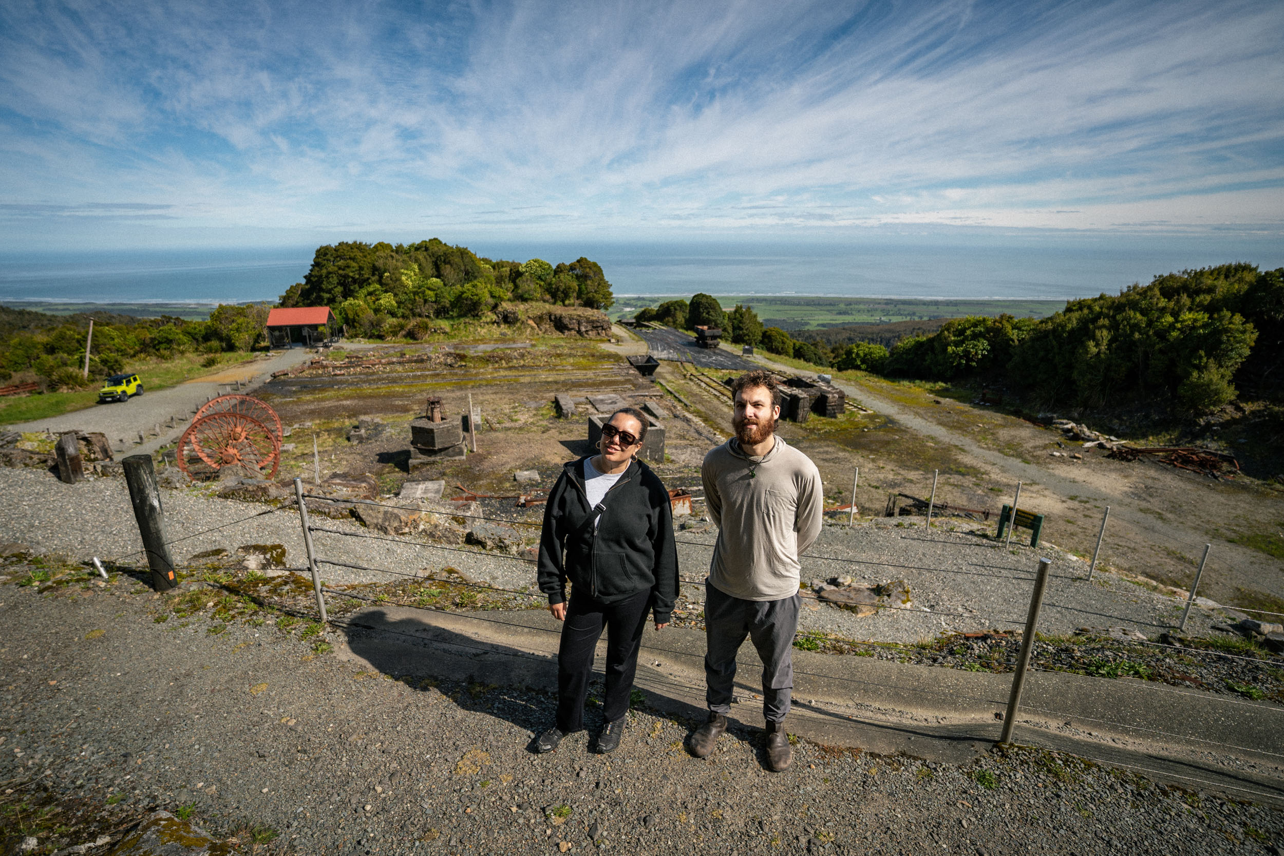 man and woman standing in front of old mine ruins