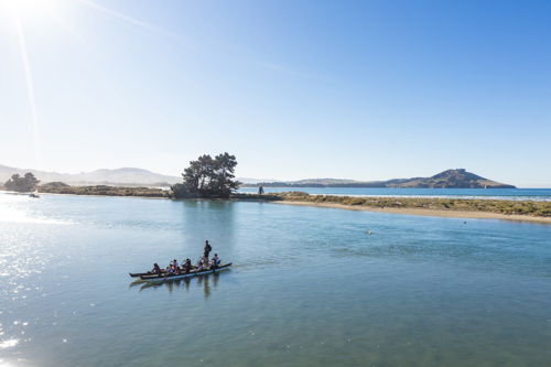Huriawa Peninsula from the sky - with people in an unua waka.