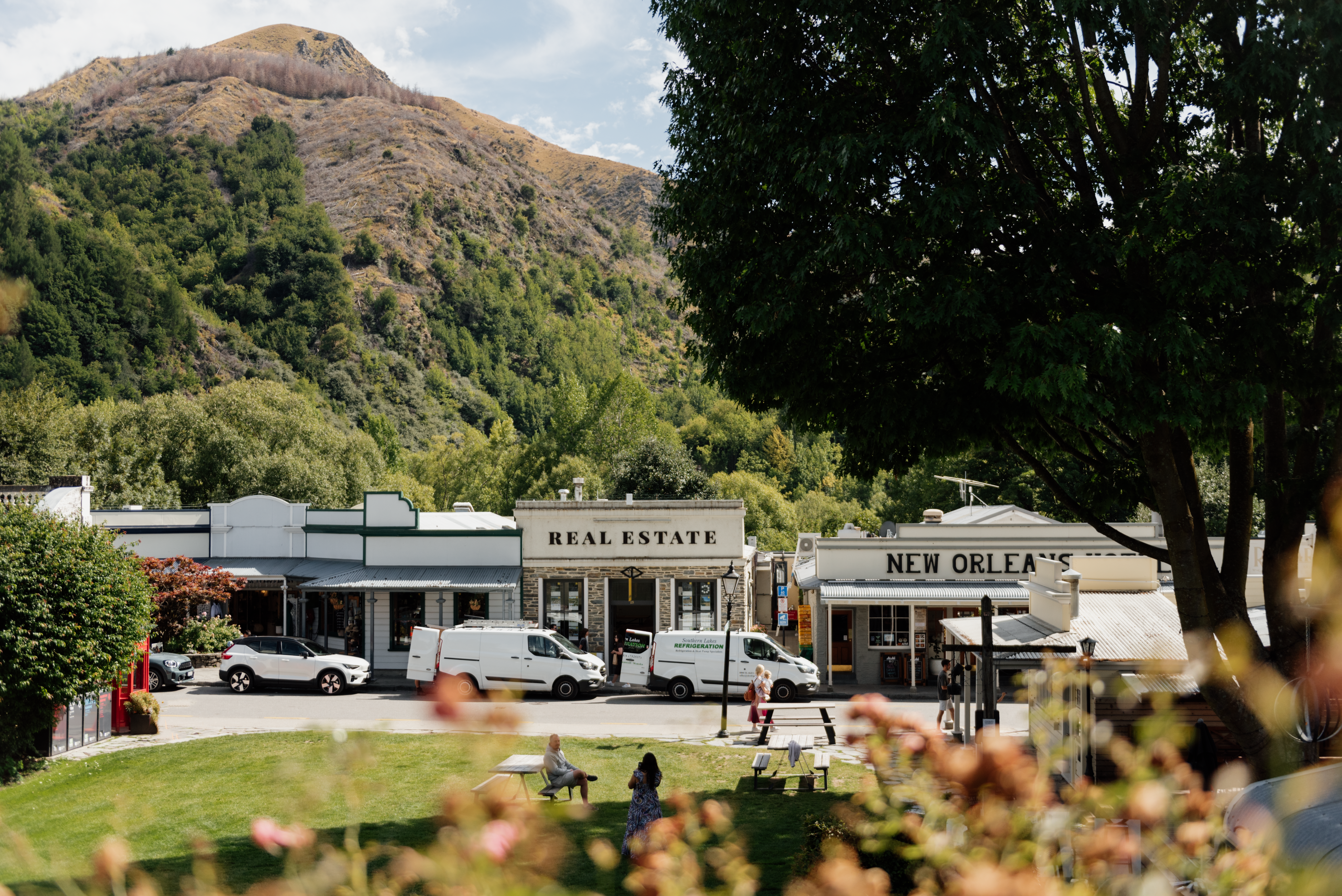 view of old fashioned shops along street with mountain in background