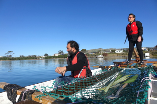 Two people on an unua waka - double hulled canoe.