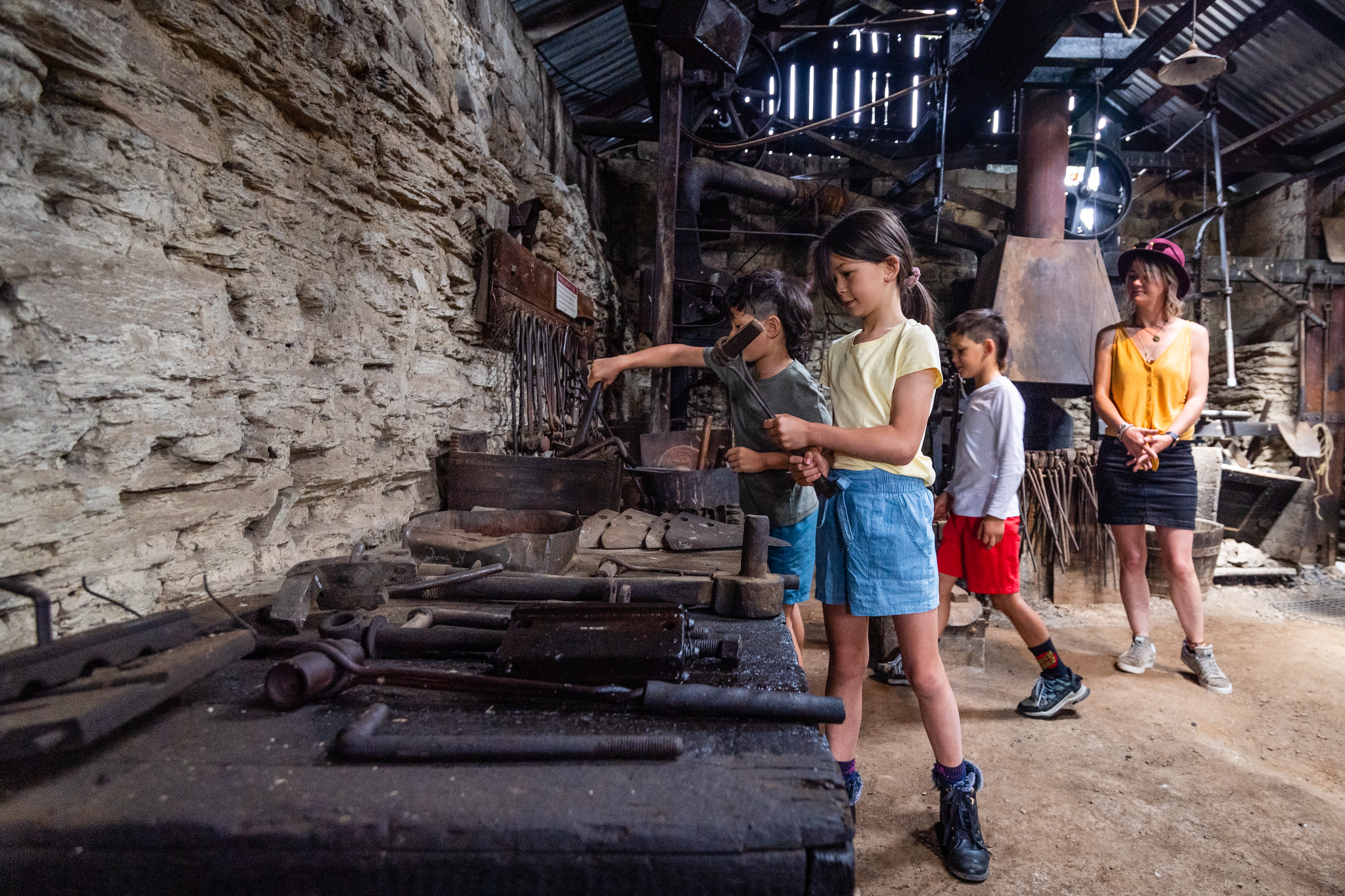children look at old machinery inside old barn