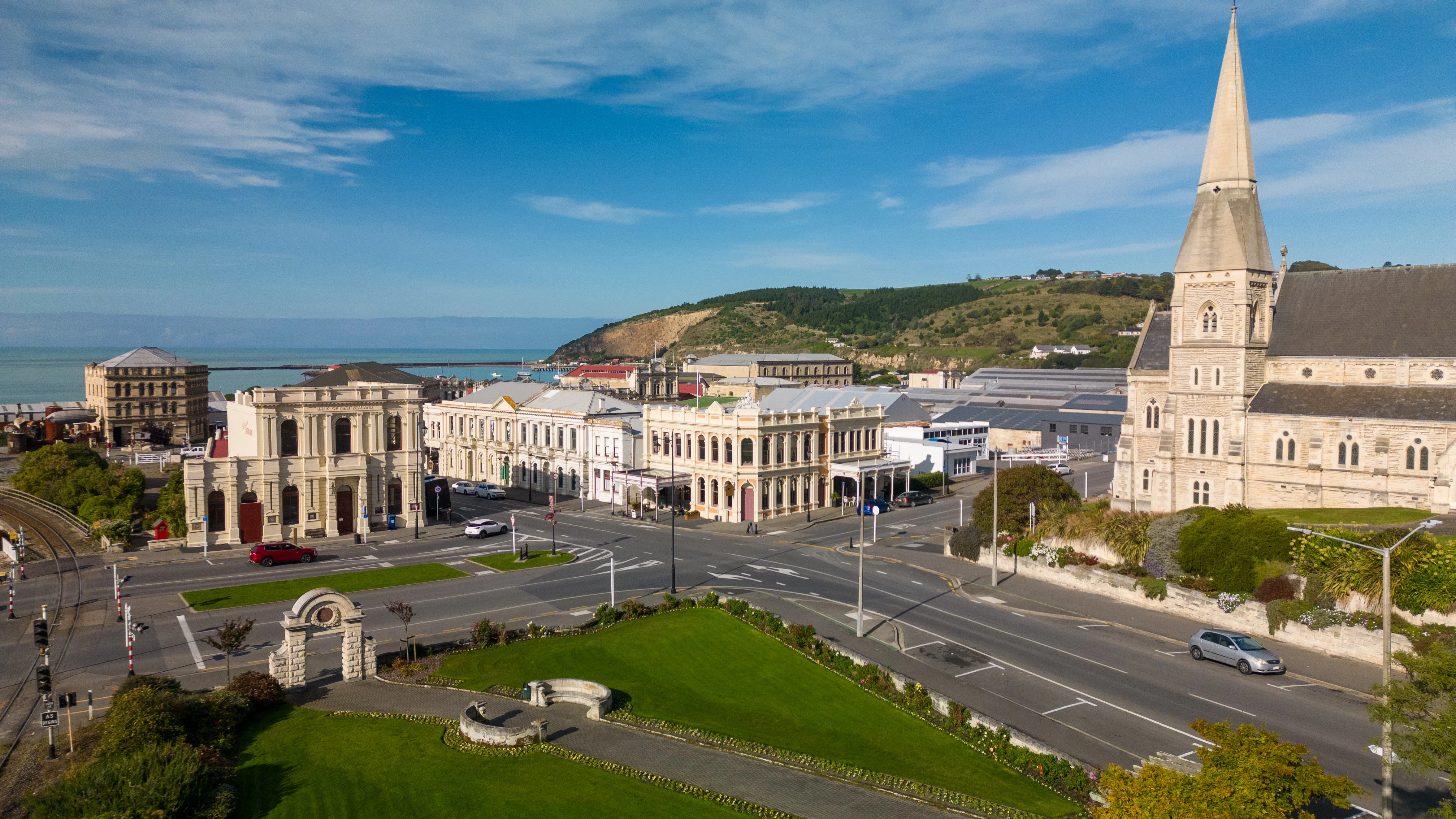 Wide shot of the limestone Victorian buildings at Oamaru - ocean and hillside in the distance, sunny day. 
